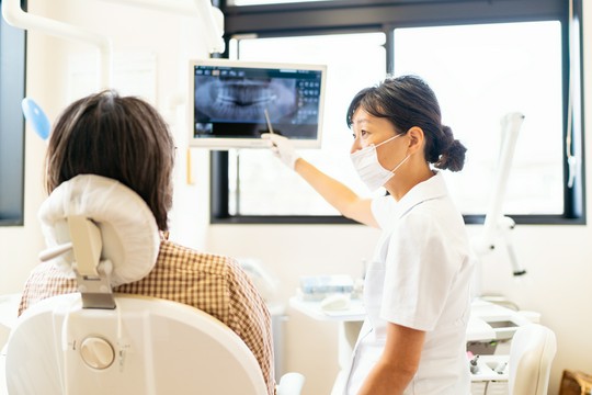 dentysta tłumaczy leczenie pacjentowi