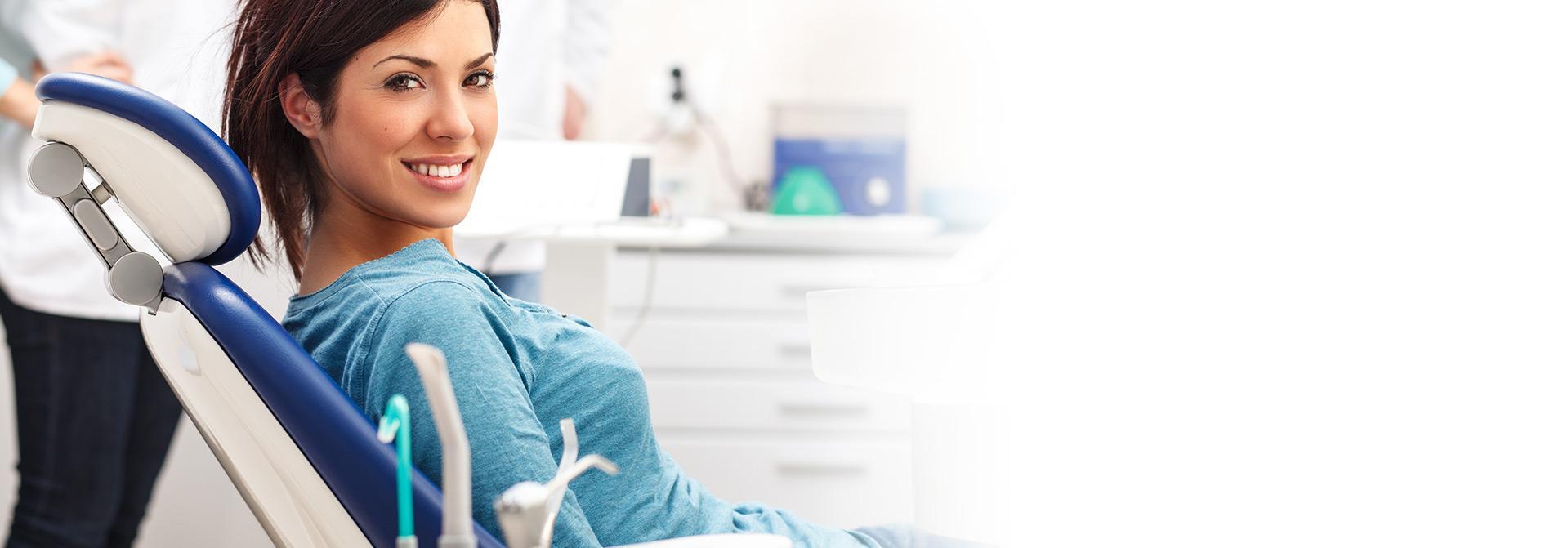 Uśmiechnięta pacjentka w gabinecie dentystycznym