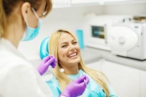 usmiechnieta pacjentka podczas zabiegu stomatologicznego